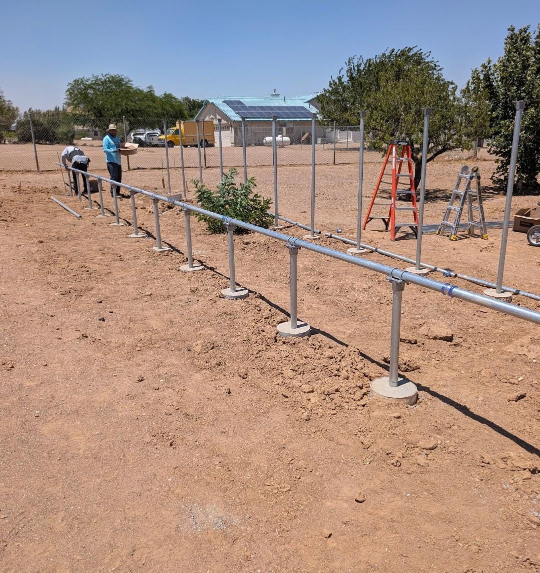 Crew installing ground-mount solar racking posts